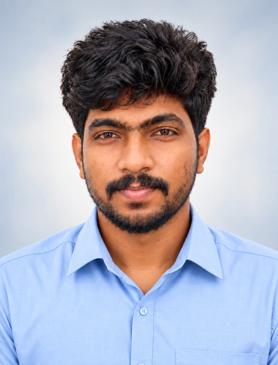 Arun R. in a light blue shirt, photographed against a soft blue-gray background